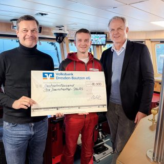 Geschäftsführer Thilo Mühle übergibt einen großen Scheck an Nicolaus Stadeler (rechts) und einen Mitarbeiter der DGzRS.