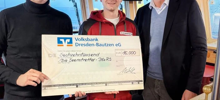 Geschäftsführer Thilo Mühle übergibt einen großen Scheck an Nicolaus Stadeler (rechts) und einen Mitarbeiter der DGzRS.