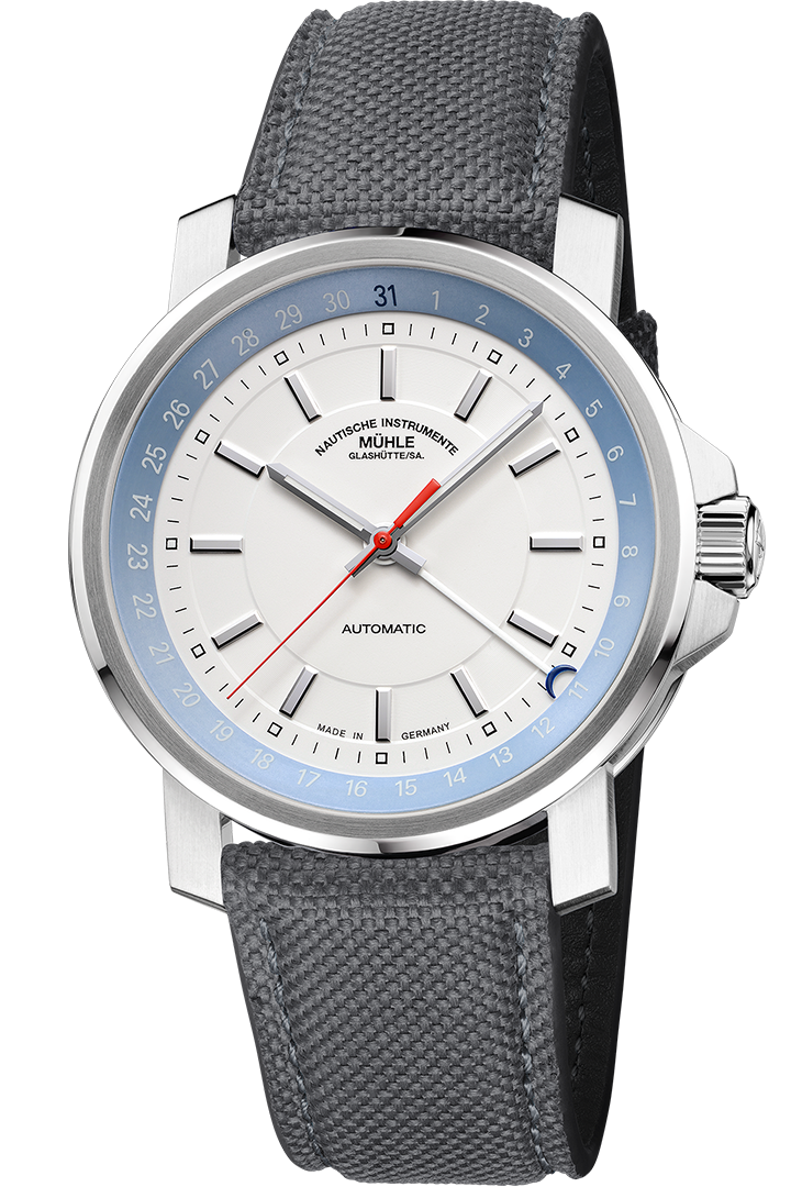 Frontalansicht der Herrenarmbanduhr 29er Big Zeigerdatum mit weißem Zifferblatt und hellblauem Rehaut im silbernen Gehäuse am grauen Canvasband.