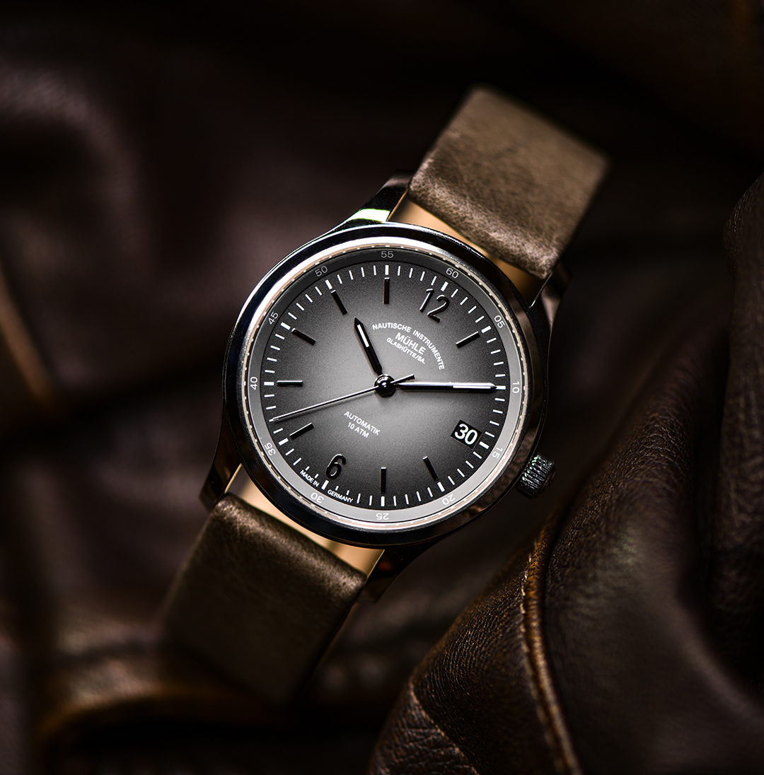 Armbanduhr Lunova Lady am grauen Lederband steht auf einer braunen Lederjacke.