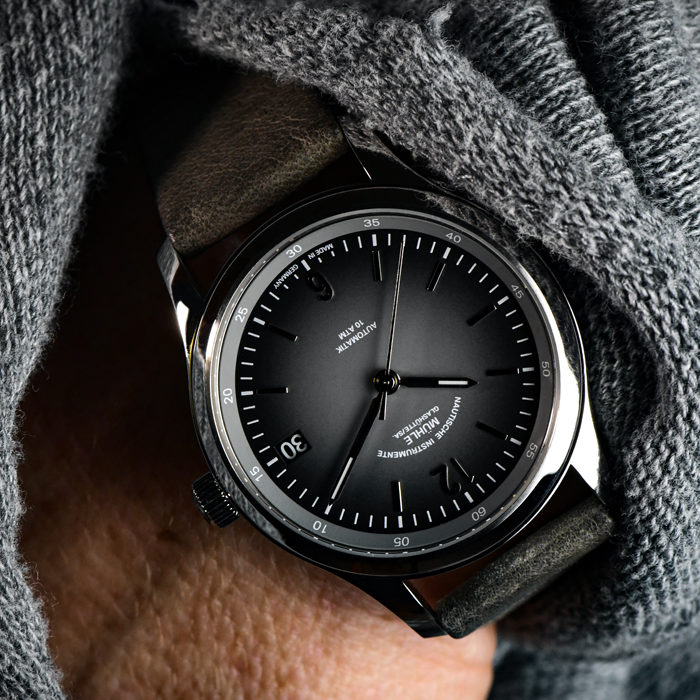 Armbanduhr Lunova Lady am grauen Lederband wird am Handgelenk getragen, die Hand ist in der Hosentasche.