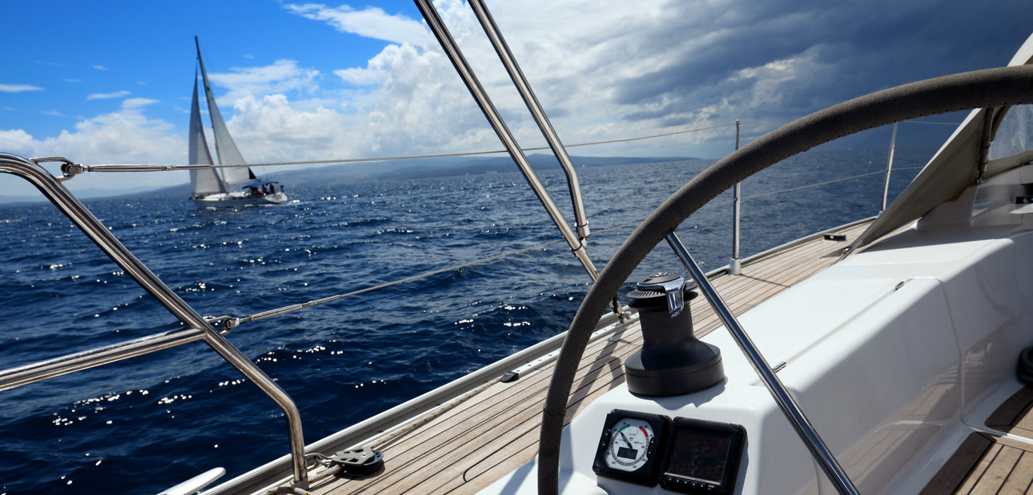 Moodbild Segelboot im Sonnenschein, am Horizont aufkommendes Unwetter