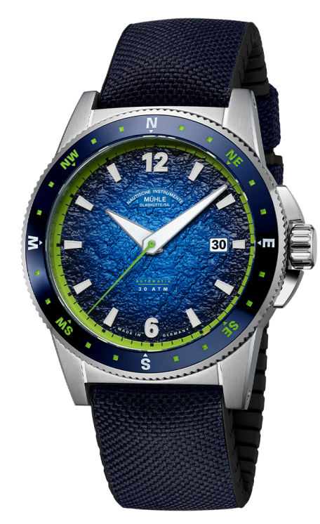 Sportivo Kompass Datum: Frontalansicht einer Armbanduhr mit blauem, strukturiertem Zifferblatt und grünen Details, Stahlgehäuse und dunkelblauem Textilband mit schwarzer Kautschukinnenseite.