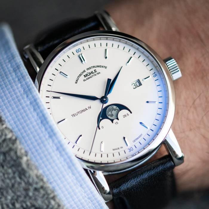 Wristshot der Teutonia Mondphase, einer Armbanduhr mit weißem Zifferblatt, blauen Zeigern und silbernen Indizes und Gehäuse.