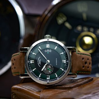 Armbanduhr Teutonia Sport II "Racing Green" am braunen Lederband liegt seitlich auf einem Stück Leder.