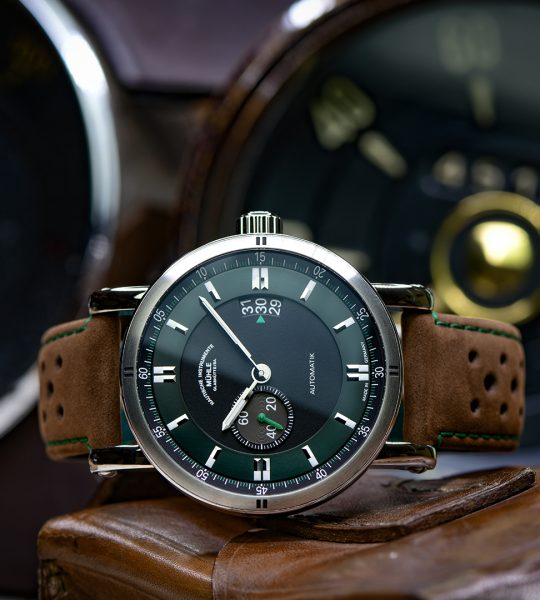 Armbanduhr Teutonia Sport II "Racing Green" am braunen Lederband liegt seitlich auf einem Stück Leder.