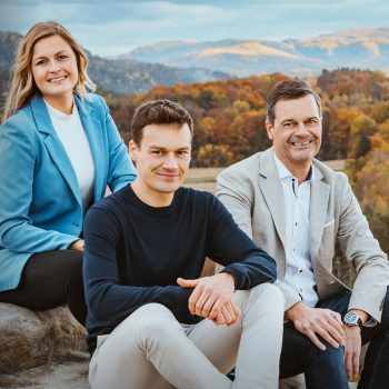 Fanny, Dustin und Thilo Mühle sitzen auf einem Felsen, im Hintergrund ein Wald der Sächsischen Schweiz