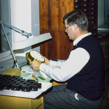 Hans-Jürgen Mühle an einem Tisch bei der Kontrolle einer Schiffsuhr