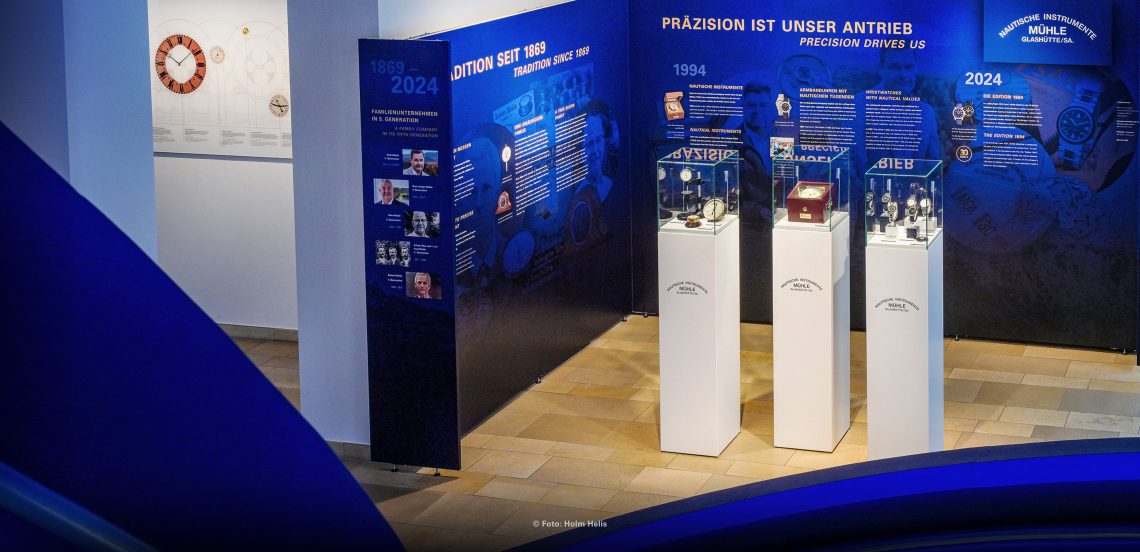 Drei Vitrinen und eine bedruckte Wand als Ausstellung über Mühle-Glashütte im Uhrenmuseum.