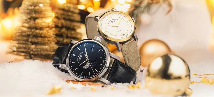 Zwei Armbanduhren (Teutonia IV Bluemoon unten, Teutonia IV Lady oben) liegen in weihnachtlicher Kulisse mit Schnee, Tannenbäumen und Weihnachtskugeln.