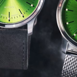 Nahaufnahme zweier Armbanduhren Panova Limettengrün am grauen Veloursband und am Metallband.