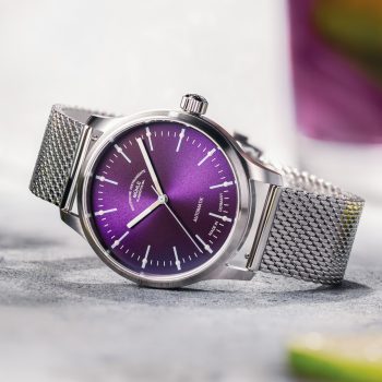Armbanduhr Panova Violett am Milanaiseband liegt seitlich auf einem weißen Tisch.