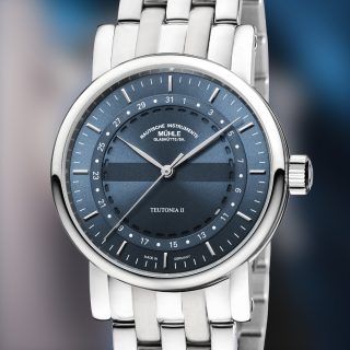 Frontalansicht Teutonia II Ringdatum - Dreizeiger-Uhr mit graublauem Zifferblatt auf dem ringförmig das Datum angeordnet ist. Edelstahlband.