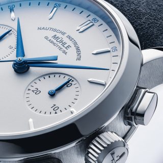 Nahaufnahme der Armbanduhr Teutonia IV Chronograph mit weißem Zifferblatt und Fokus auf die blauen Zeiger.