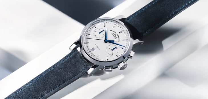 Armbanduhr Teutonia IV Chronograph mit weißem Zifferblatt, silbernem Gehäuse und blauem Velourslederband liegt auf einem weißen Untergrund.